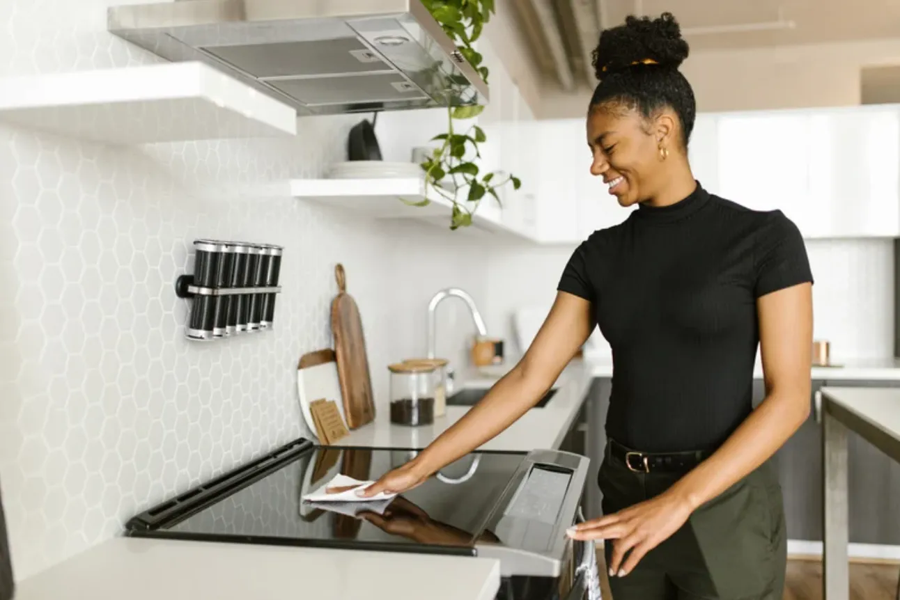 A housekeeper wiping down a modern kitchen counter