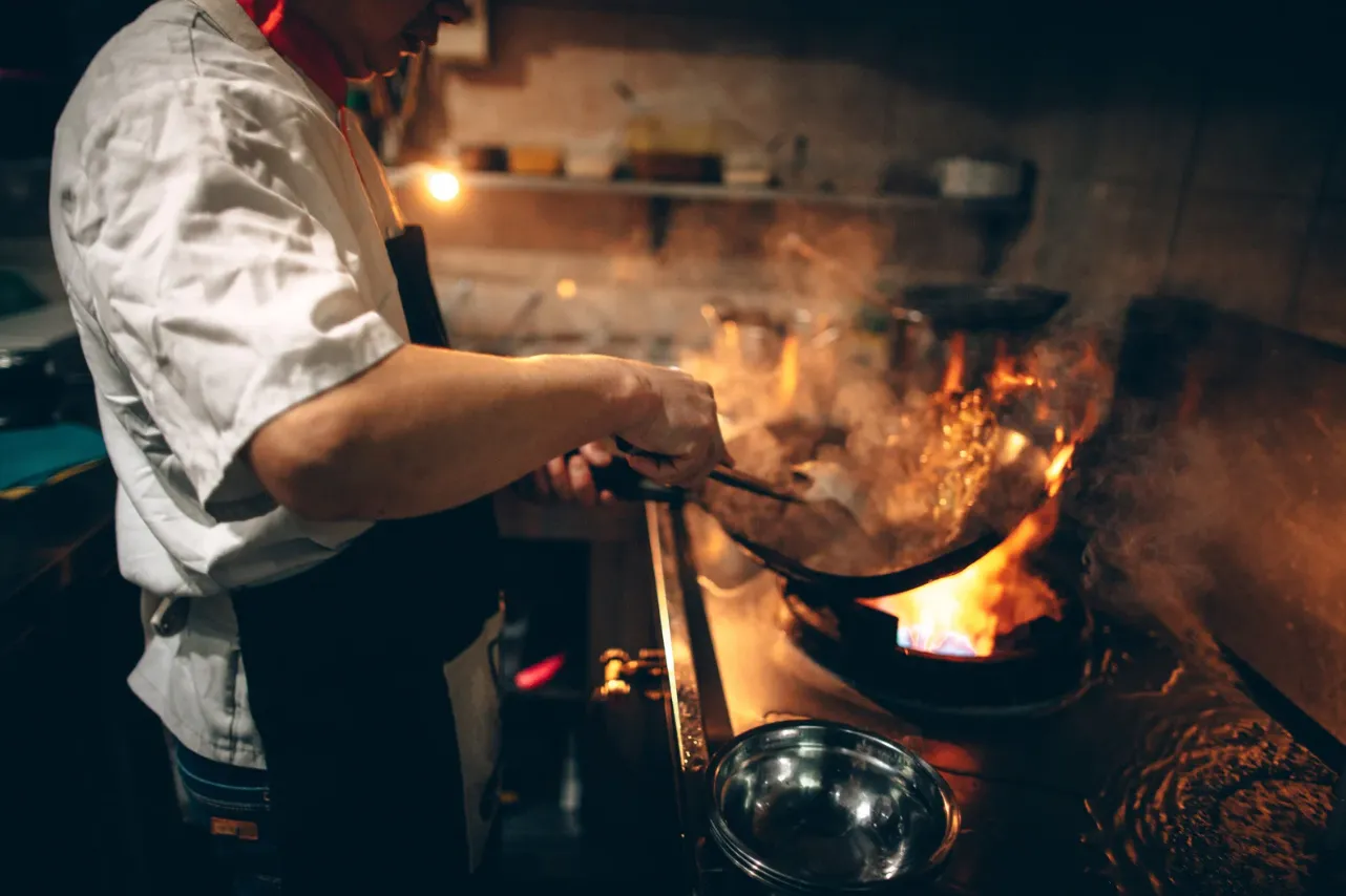 A private chef cooking over a flaming pan